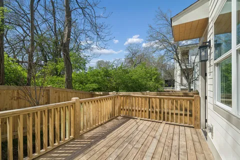 a view of a wooden deck with large trees