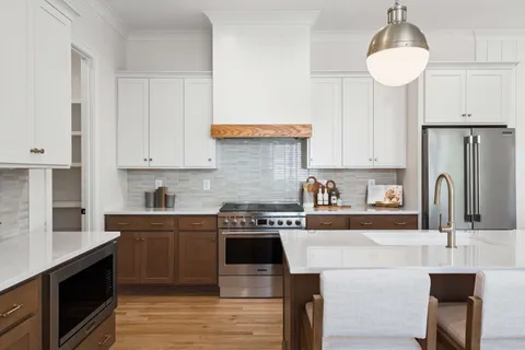 a kitchen with kitchen island granite countertop a sink a stove and refrigerator