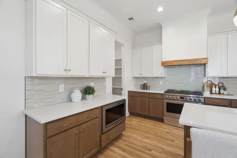 a kitchen with granite countertop white cabinets and white appliances