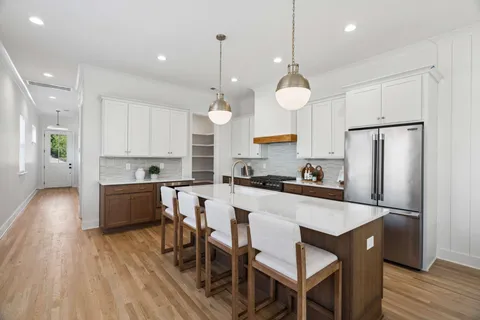 a kitchen with a dining table chairs refrigerator and microwave