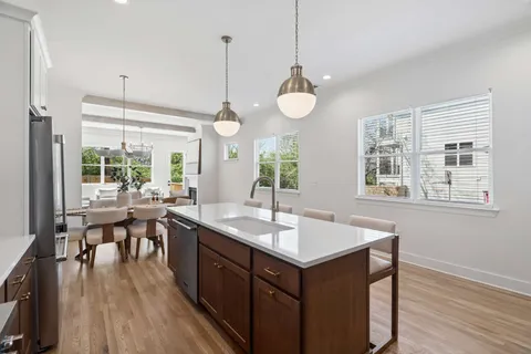 a kitchen with a table chairs stove and wooden floor
