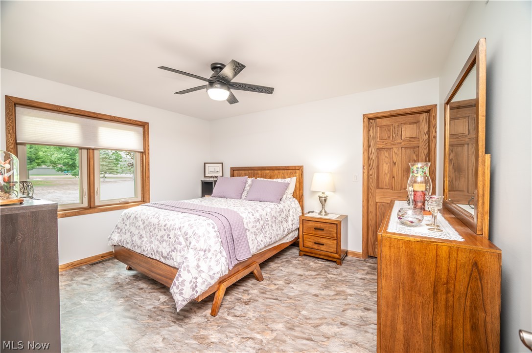 405 Airport Road Northwest Warren, OH 44481 - Photo 31 of 50 Bedroom featuring a ceiling fan with integrated lighting, and a window with wood trim