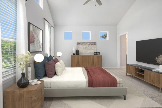 a bedroom with a bed and a flat tv screen on the dresser