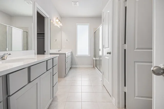 a bathroom with a double vanity sink a mirror and a bathtub