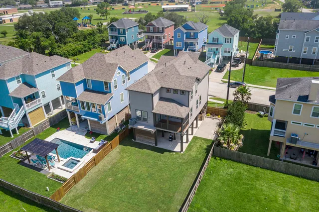 an aerial view of a house with a garden swimming pool and outdoor seating