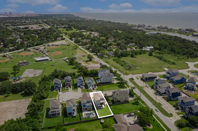 an aerial view of a house with a garden and lake view