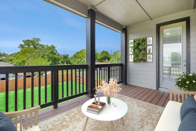 a view of a balcony with chairs and wooden floor