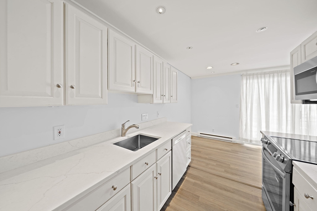 1204 Greendale Avenue, Unit 128 Needham, MA 02492 - Photo 11 of 27 a kitchen with white cabinets and sink