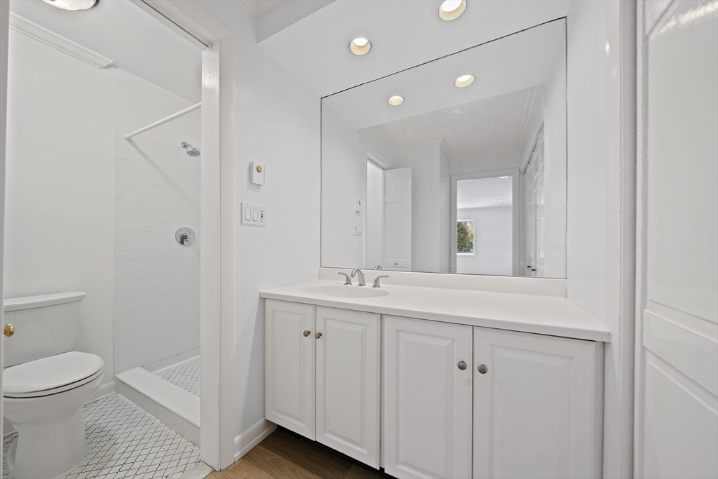 1204 Greendale Avenue, Unit 128 Needham, MA 02492 - Photo 16 of 27 a bathroom with a toilet a sink and mirror