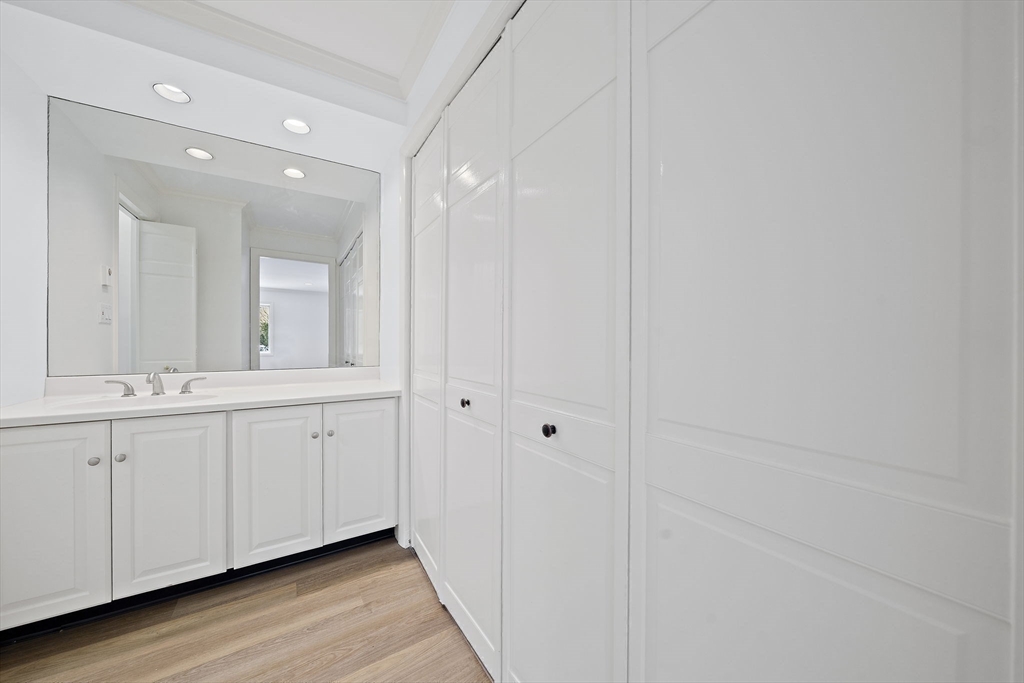 1204 Greendale Avenue, Unit 128 Needham, MA 02492 - Photo 18 of 27 a bathroom with a double vanity sink and mirror