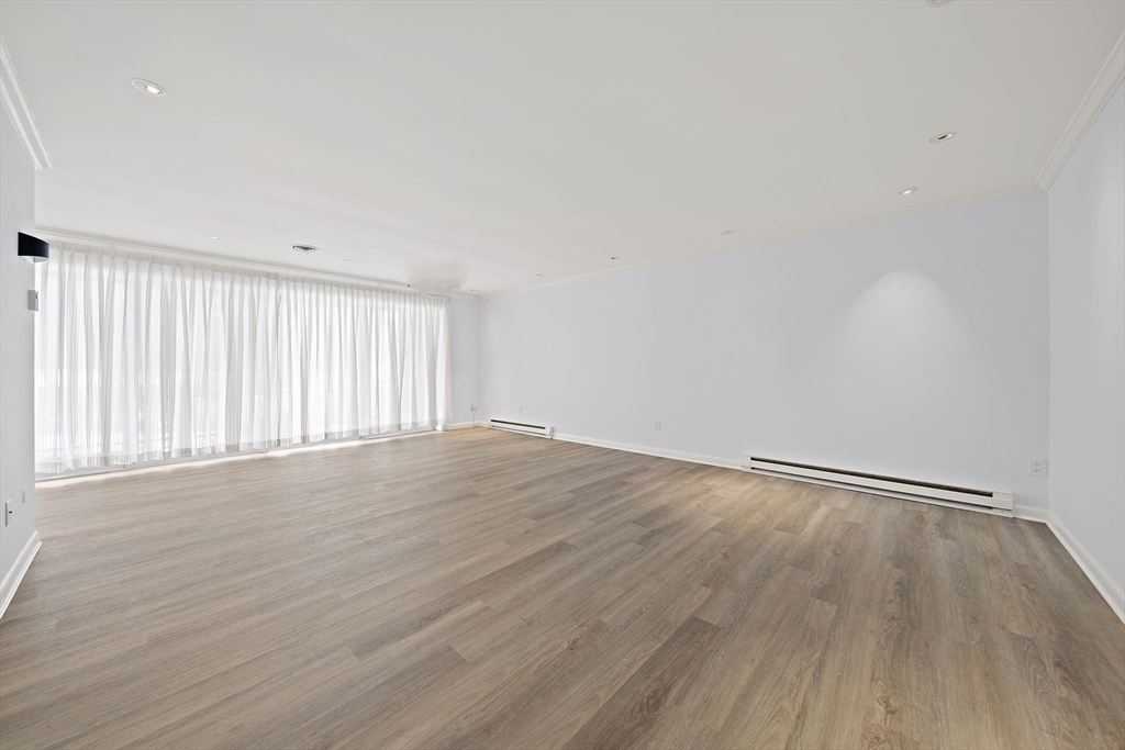 1204 Greendale Avenue, Unit 128 Needham, MA 02492 - Photo 3 of 27 a view of an empty room with wooden floor and a window