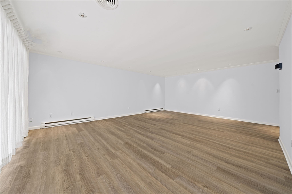1204 Greendale Avenue, Unit 128 Needham, MA 02492 - Photo 5 of 27 a view of an empty room with wooden floor