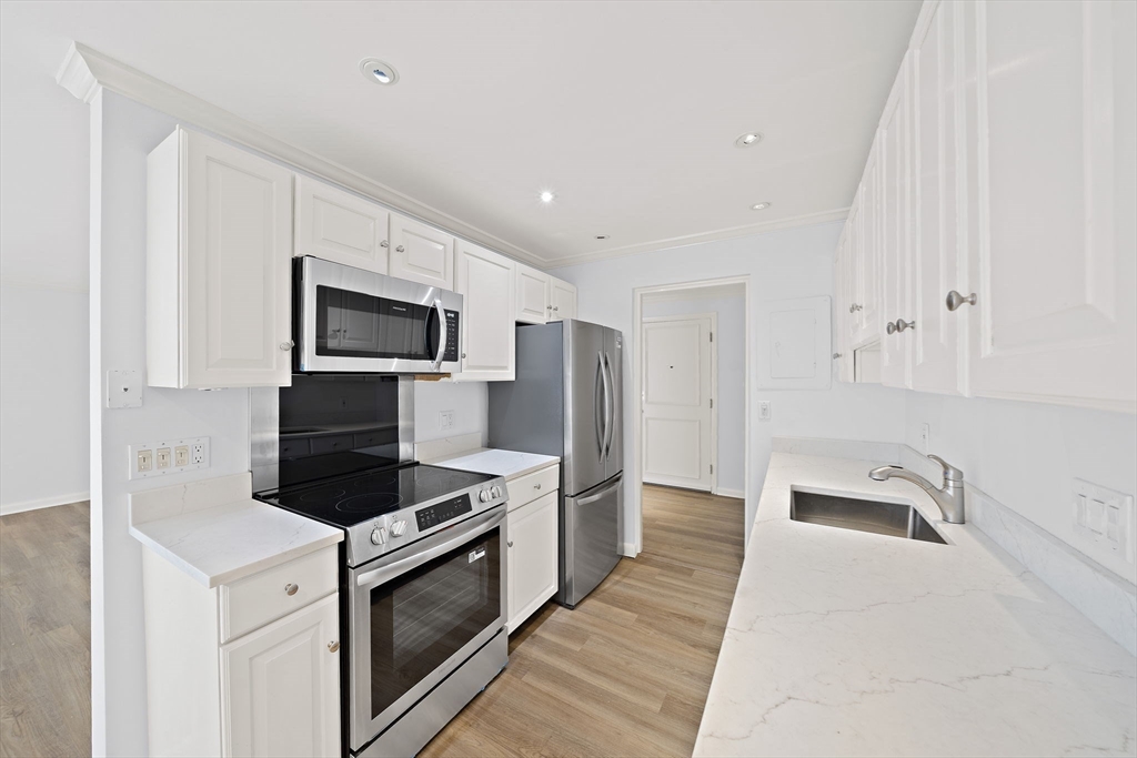 1204 Greendale Avenue, Unit 128 Needham, MA 02492 - Photo 7 of 27 a kitchen with white cabinets and stainless steel appliances