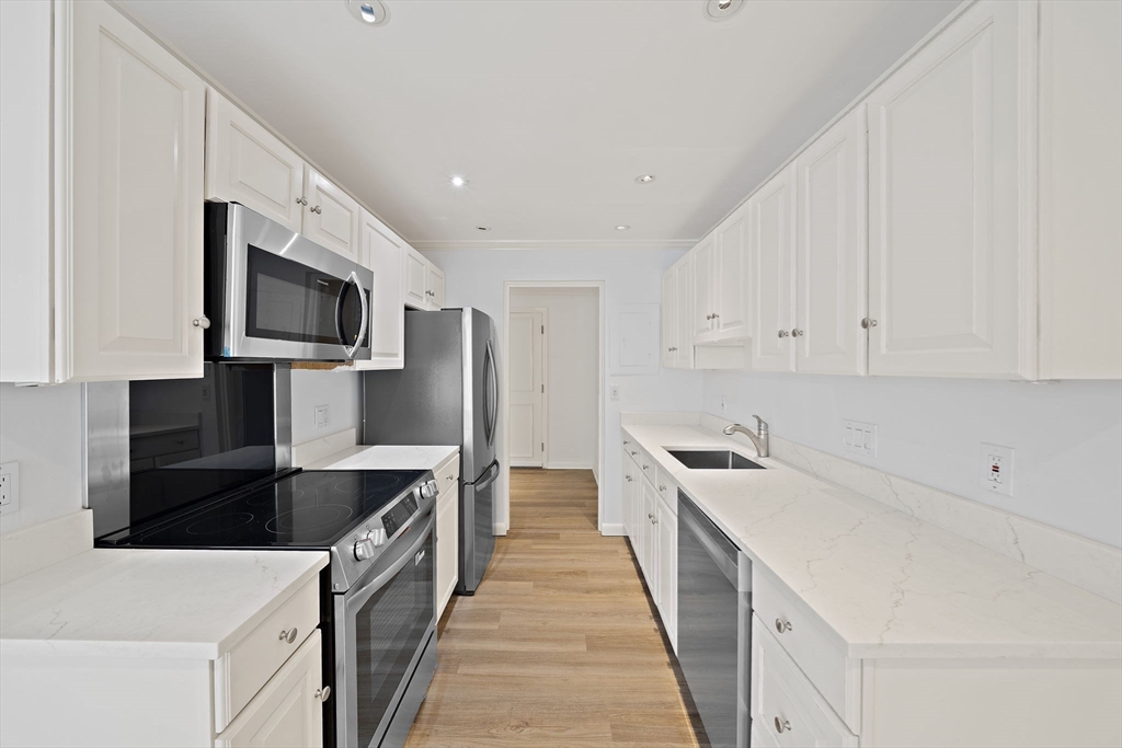 1204 Greendale Avenue, Unit 128 Needham, MA 02492 - Photo 8 of 27 a kitchen with stainless steel appliances a refrigerator sink and microwave