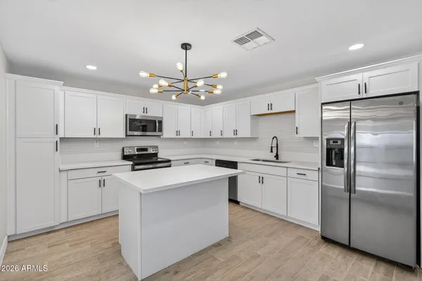 a kitchen with stainless steel appliances a refrigerator sink and microwave