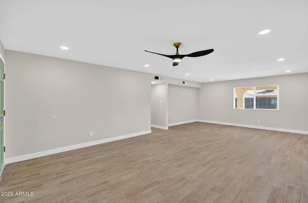an empty room with a window and a ceiling fan