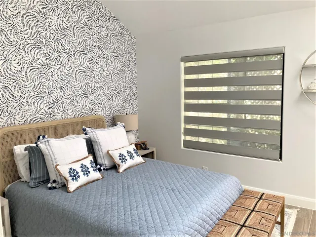 a bed sitting in a bedroom next to a window