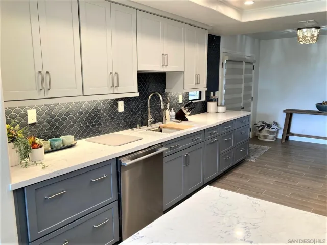a kitchen with stainless steel appliances granite countertop a sink a stove and cabinets