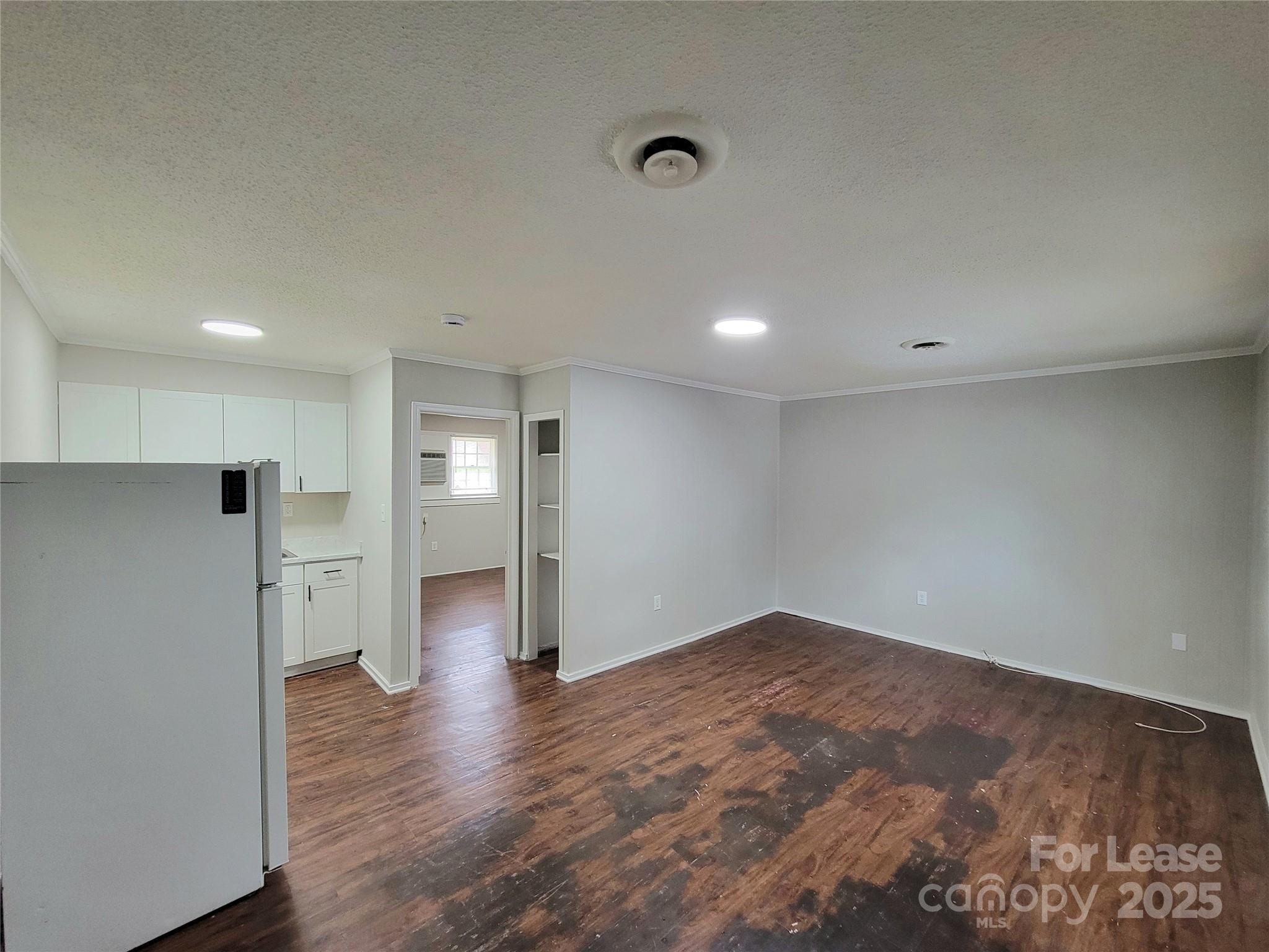 1203 Butler Street, Unit 1203D Gastonia, NC 28054 - Photo 2 of 5 a view of an empty room with wooden floor and a window