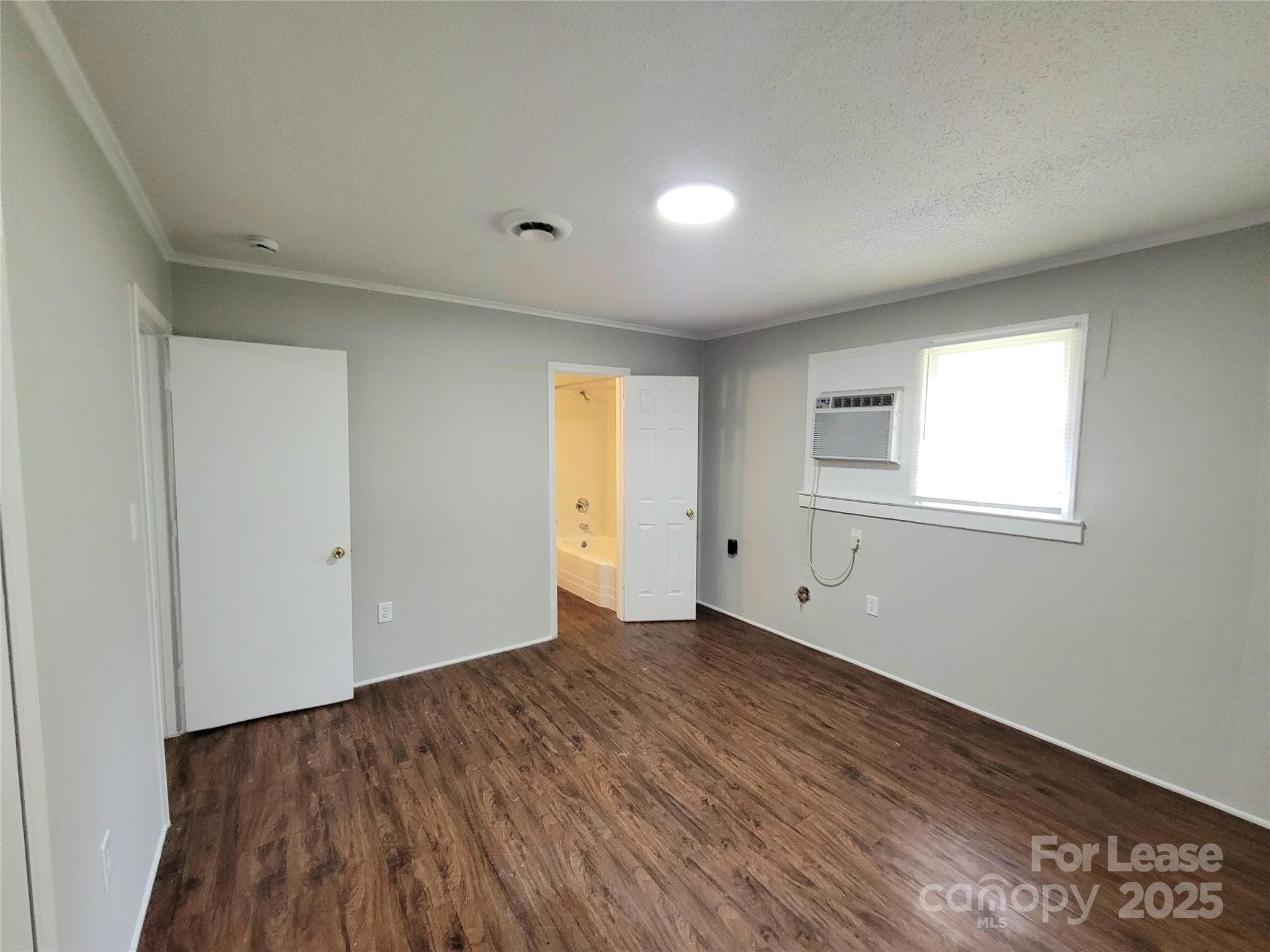 1203 Butler Street, Unit 1203D Gastonia, NC 28054 - Photo 4 of 5 a view of an empty room with wooden floor and a window