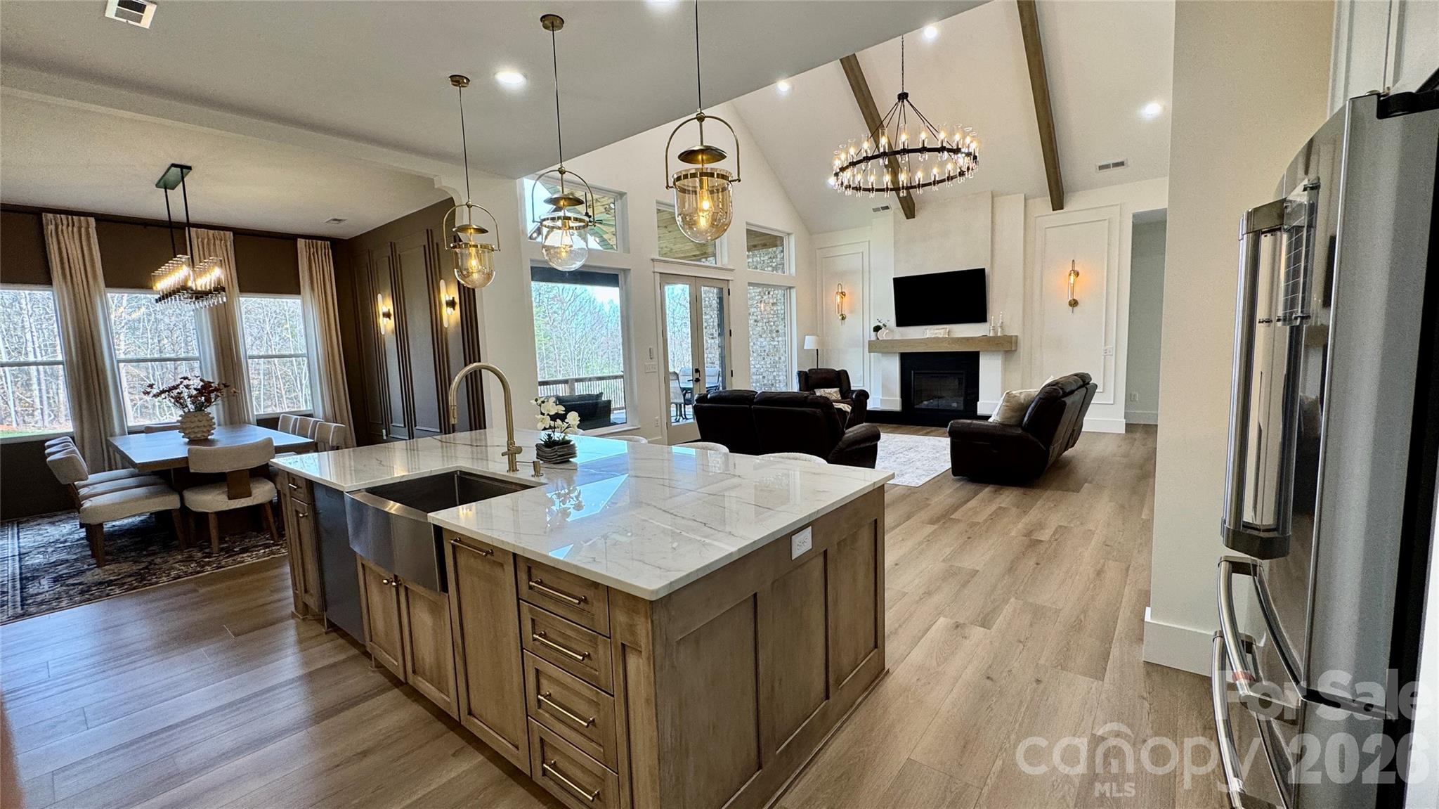 1360 Sain Road Hickory, NC 28602 - Photo 13 of 47 a large kitchen with stainless steel appliances a stove a refrigerator a sink dishwasher a dining table and chairs with wooden floor