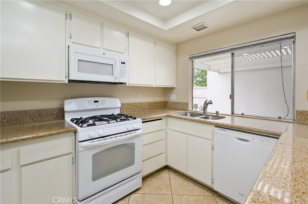 25 Sweet Rain Irvine, CA 92614 - Photo 11 of 45 a kitchen with granite countertop white cabinets and white appliances