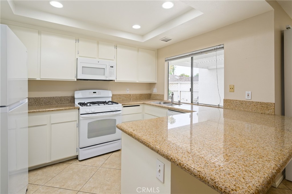 25 Sweet Rain Irvine, CA 92614 - Photo 10 of 45 a kitchen with granite countertop a sink stove and cabinets
