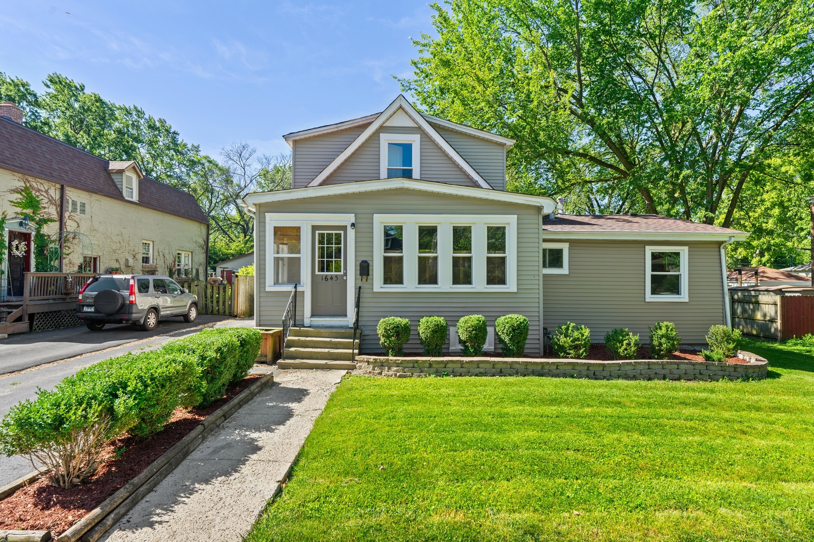 a front view of a house with a garden and plants