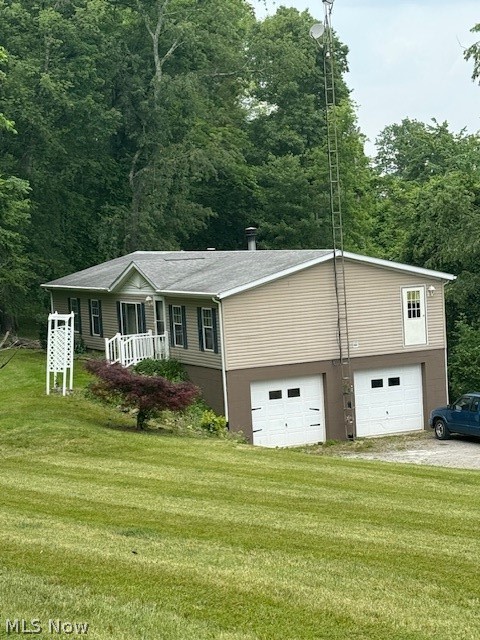 View of front of home with a front yard, driveway, and a garage