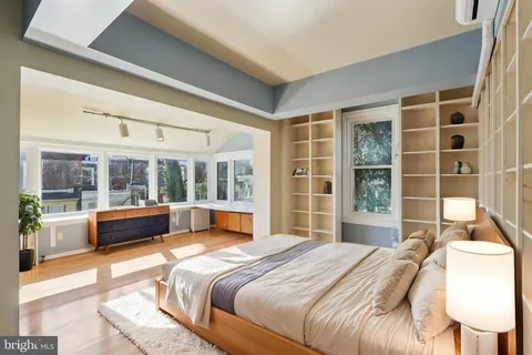 a spacious bedroom with a large bed and a chandelier