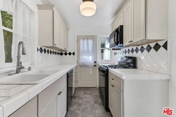 a kitchen with a sink stove and cabinets