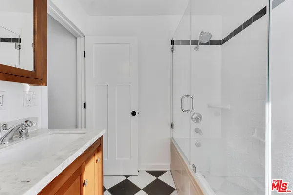 a bathroom with a granite countertop sink mirror and shower