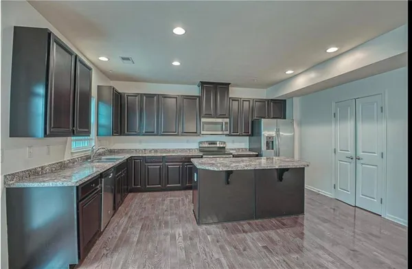 a kitchen with stainless steel appliances granite countertop sink stove and cabinets