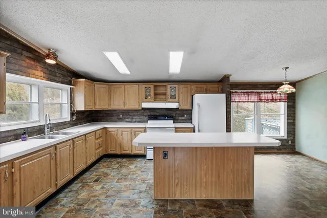 a large kitchen with kitchen island a sink stainless steel appliances and cabinets