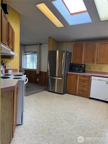 a kitchen with stainless steel appliances a refrigerator and a stove top oven