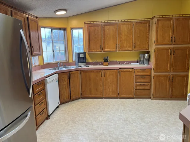 a kitchen with stainless steel appliances a refrigerator and wooden cabinets