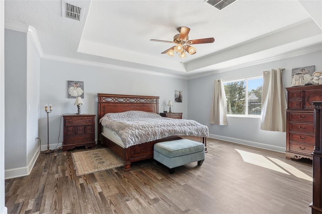 5047 Rishley Run Way Mount Dora, FL 32757 - Photo 17 of 42 a bedroom with a bed a dresser and a window
