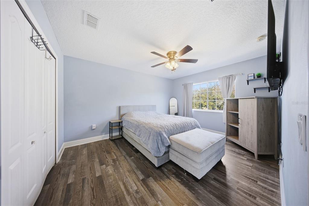 5047 Rishley Run Way Mount Dora, FL 32757 - Photo 23 of 42 a spacious bedroom with a bed and a chandelier