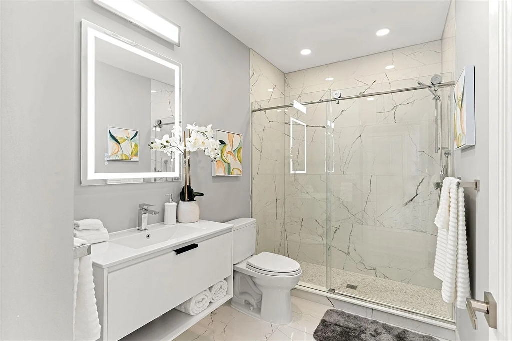 124 Warren Street, Unit 302 Boston, MA 02119 - Photo 16 of 24 a bathroom with a toilet sink and shower