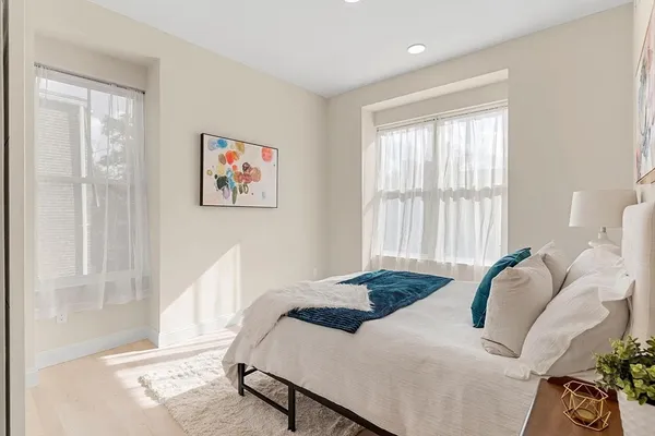 a bedroom with a bed and a large window