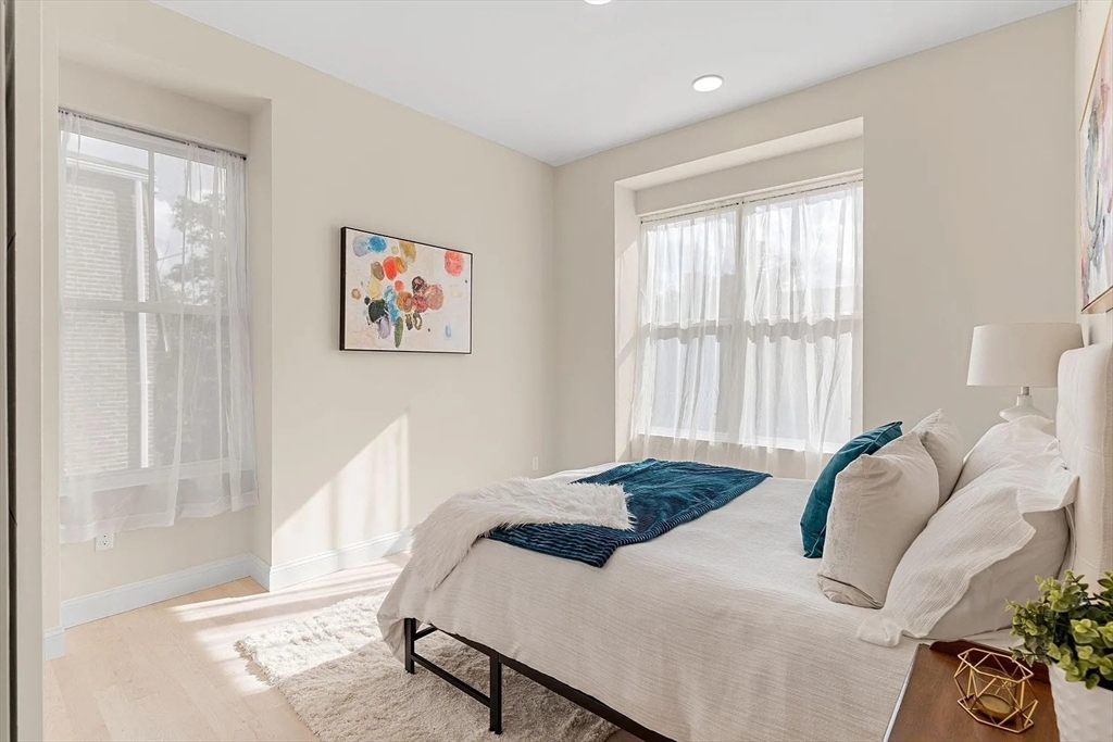 124 Warren Street, Unit 302 Boston, MA 02119 - Photo 18 of 24 a bedroom with a bed and a large window