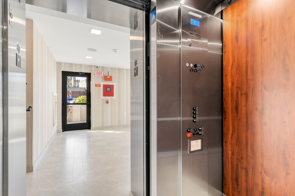 124 Warren Street, Unit 302 Boston, MA 02119 - Photo 2 of 24 a view of a hallway with wooden shelves
