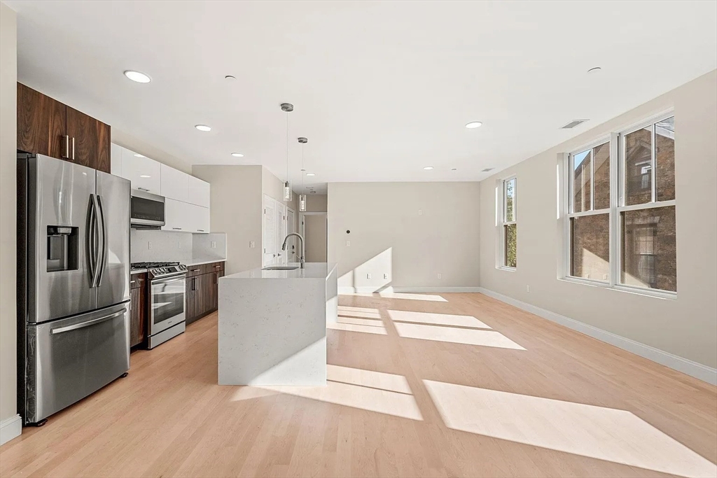 124 Warren Street, Unit 302 Boston, MA 02119 - Photo 3 of 24 a kitchen with granite countertop a refrigerator and a sink