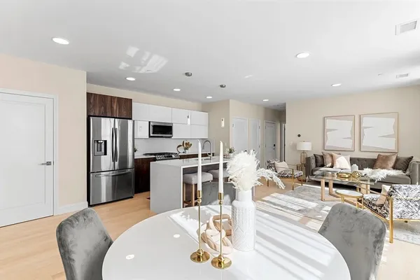 a living room with stainless steel appliances furniture or kitchen and a wooden floor