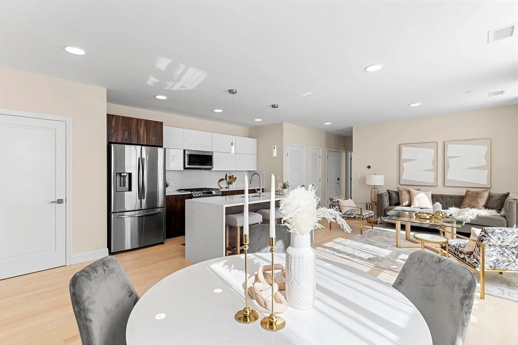 124 Warren Street, Unit 302 Boston, MA 02119 - Photo 6 of 24 a living room with stainless steel appliances furniture or kitchen and a wooden floor