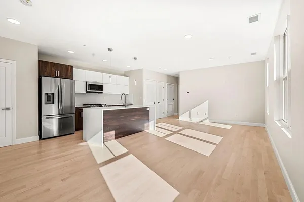 a kitchen with stainless steel appliances kitchen island sink refrigerator and cabinets