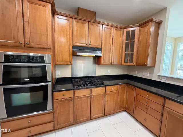 a large kitchen with a large counter top and stainless steel appliances
