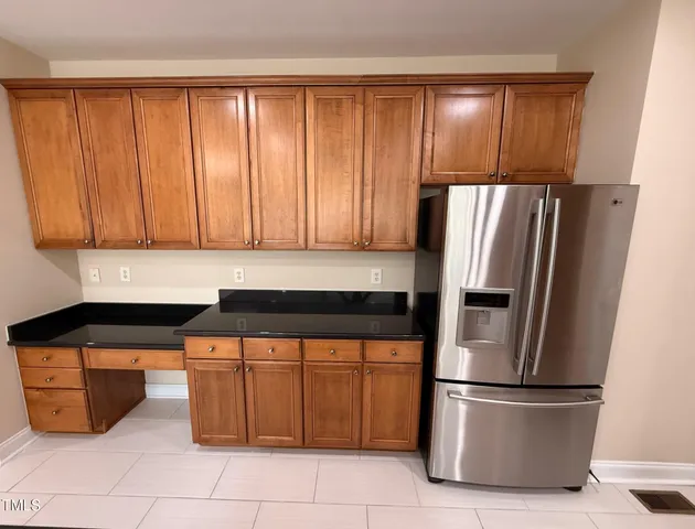 a kitchen with stainless steel appliances granite countertop a refrigerator and a sink
