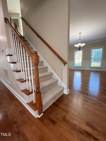 a view of a livingroom with a chandelier fan and windows