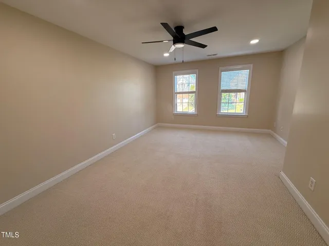 en empty room with windows and ceiling fan